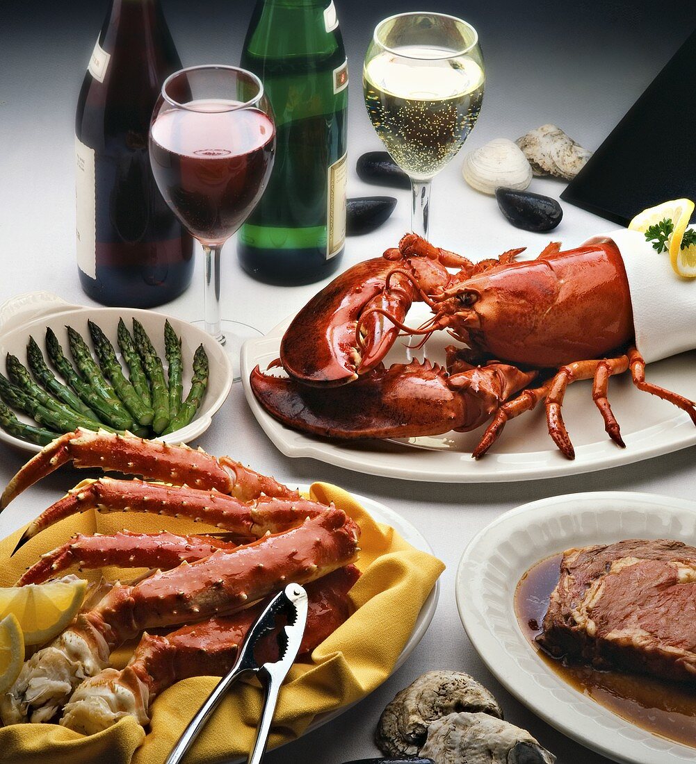 Hummer, Krabbe und Steak auf Platten mit Wein