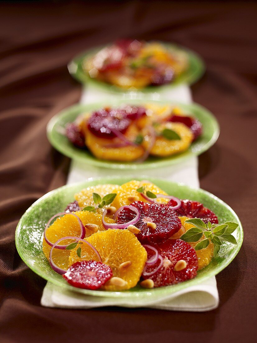 Zitrusfrüchtesalat mit roten Zwiebeln auf drei Tellern