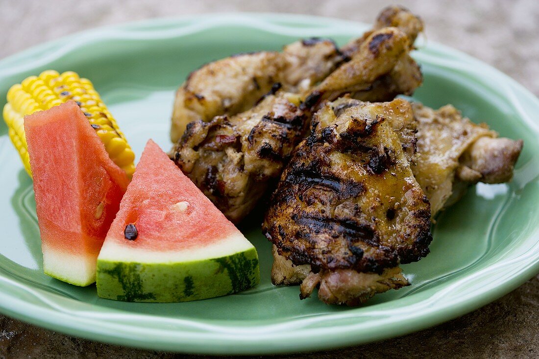 Gegrillte Hähnchenteile mit Maiskolben und Wassermelone