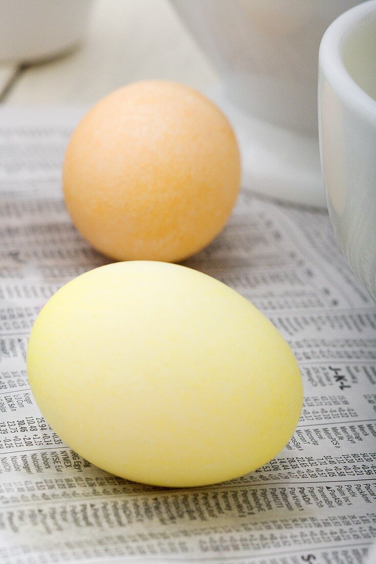Zwei gefärbte Eier auf Zeitungspapier