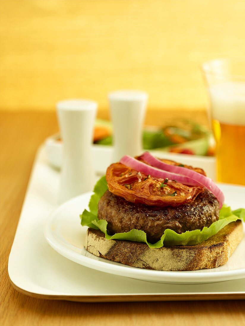 Belegtes Brot mit Frikadelle, Salat, Tomate und Zwiebel