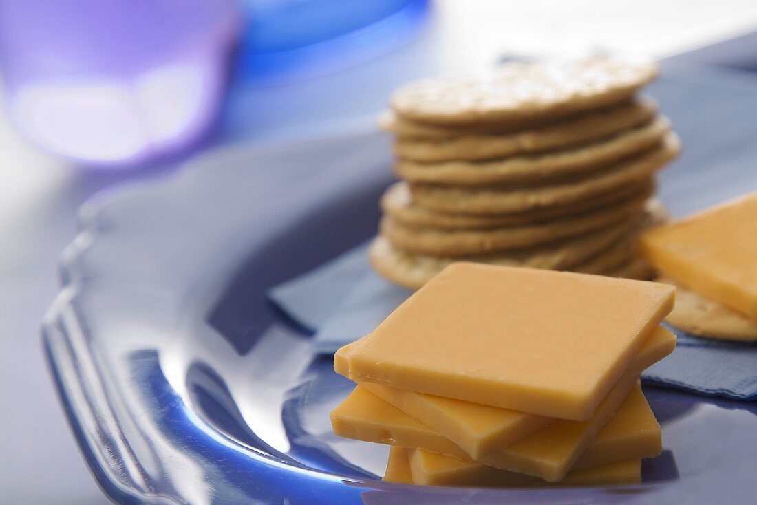 Stack of Orange Cheddar Cheese Slices with Crackers