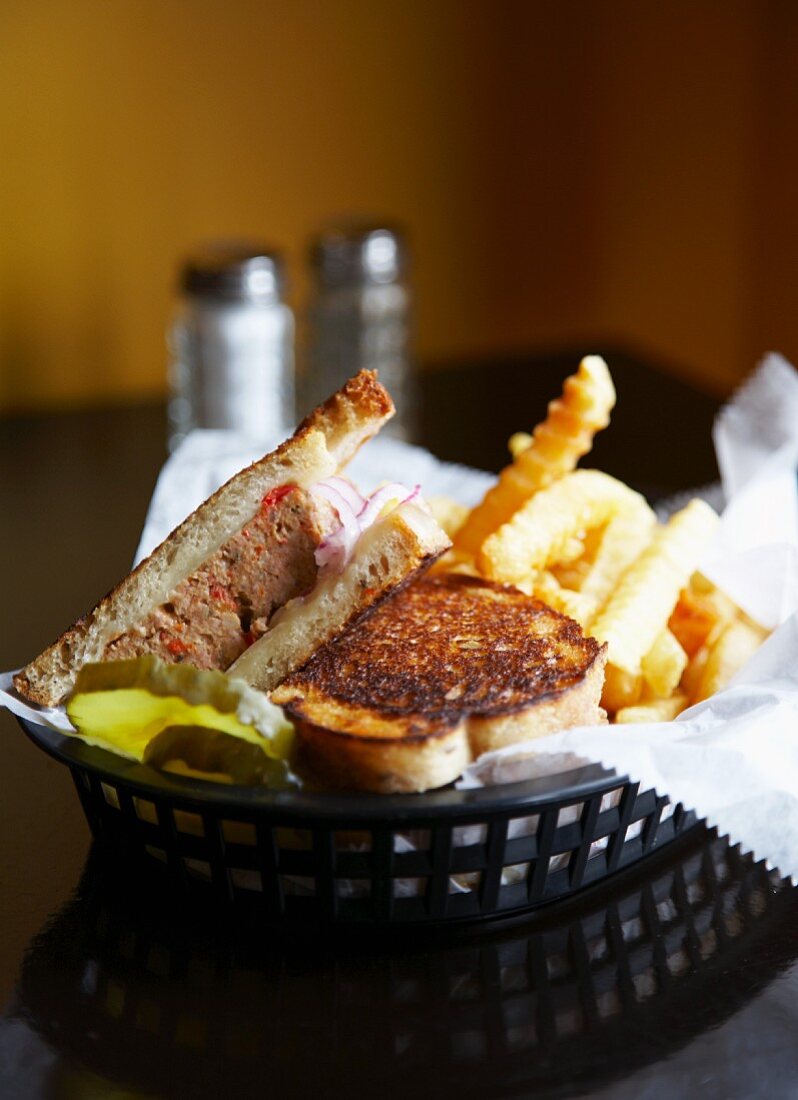 Hackbraten-Sandwich mit Pommes in einem Körbchen