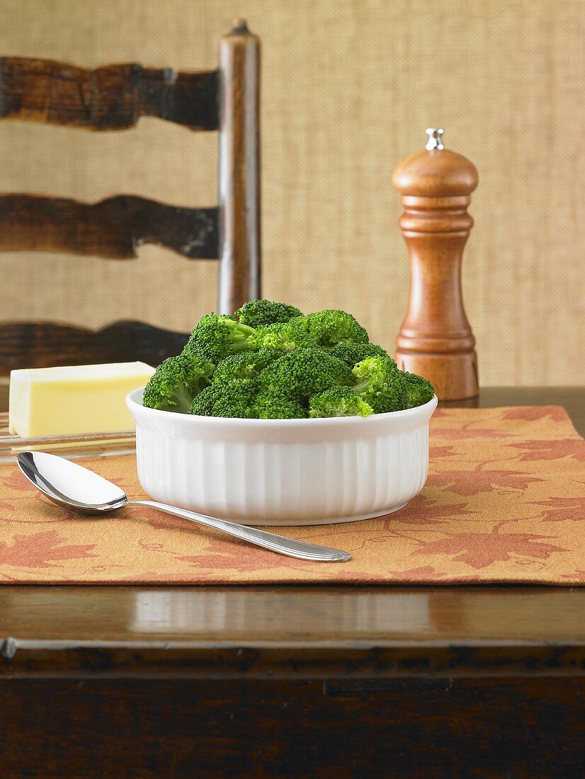 Gedämpfter Brokkoli mit Butter, Pfeffermühle auf einem Tisch