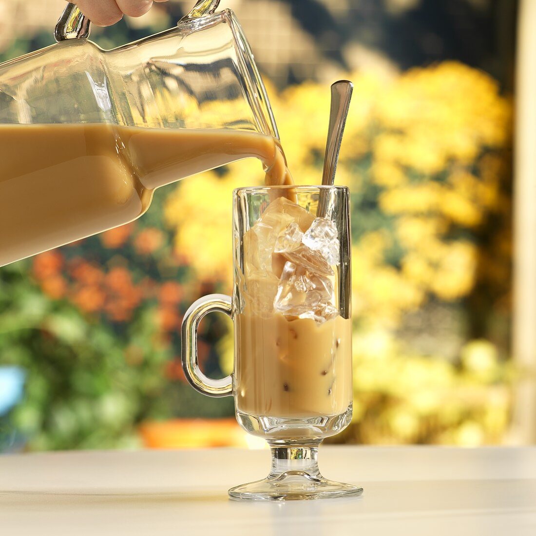 Ice Coffee Pouring into a Glass from Pitcher