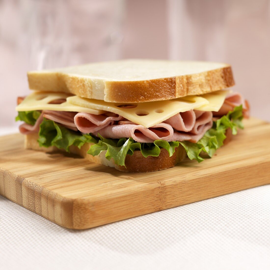Ham and Swiss Sandwich on White Bread on Cutting Board