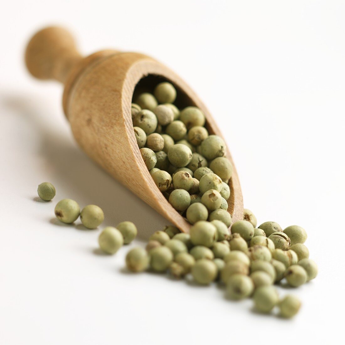 Green Pepper Berries Spilling from a Wooden Scoop