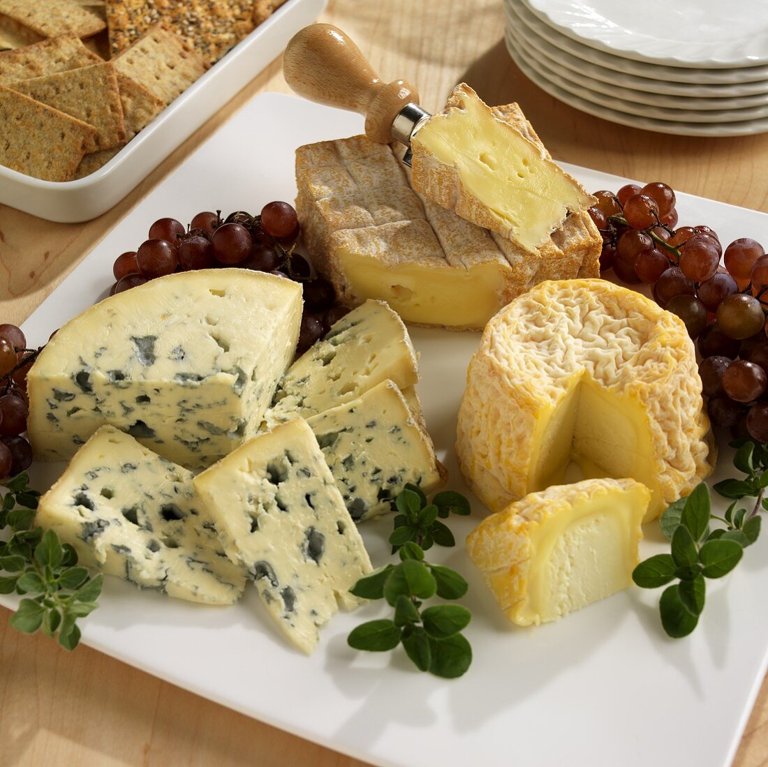 Three French Cheeses on a Board with Grapes