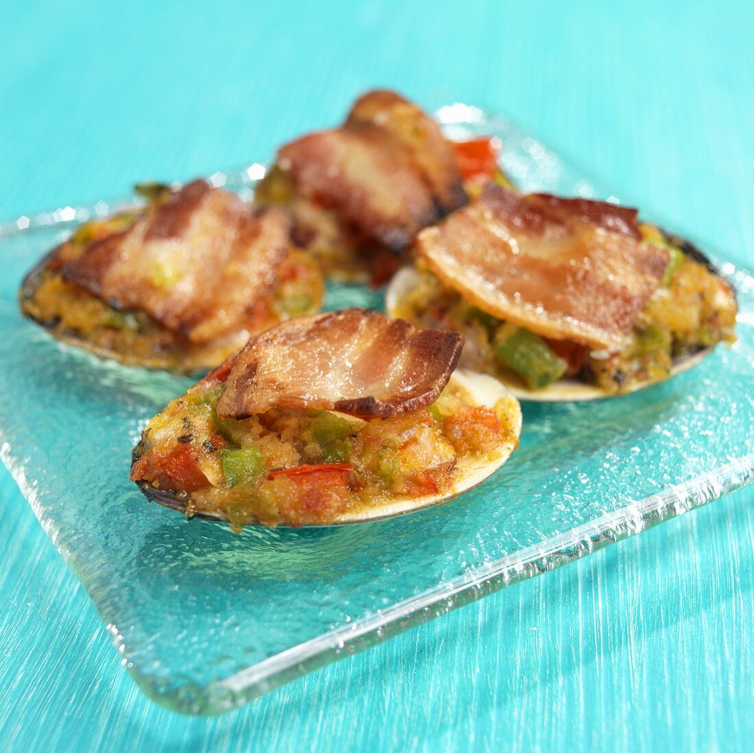 Überbackene Clams mit Bacon auf Glasteller