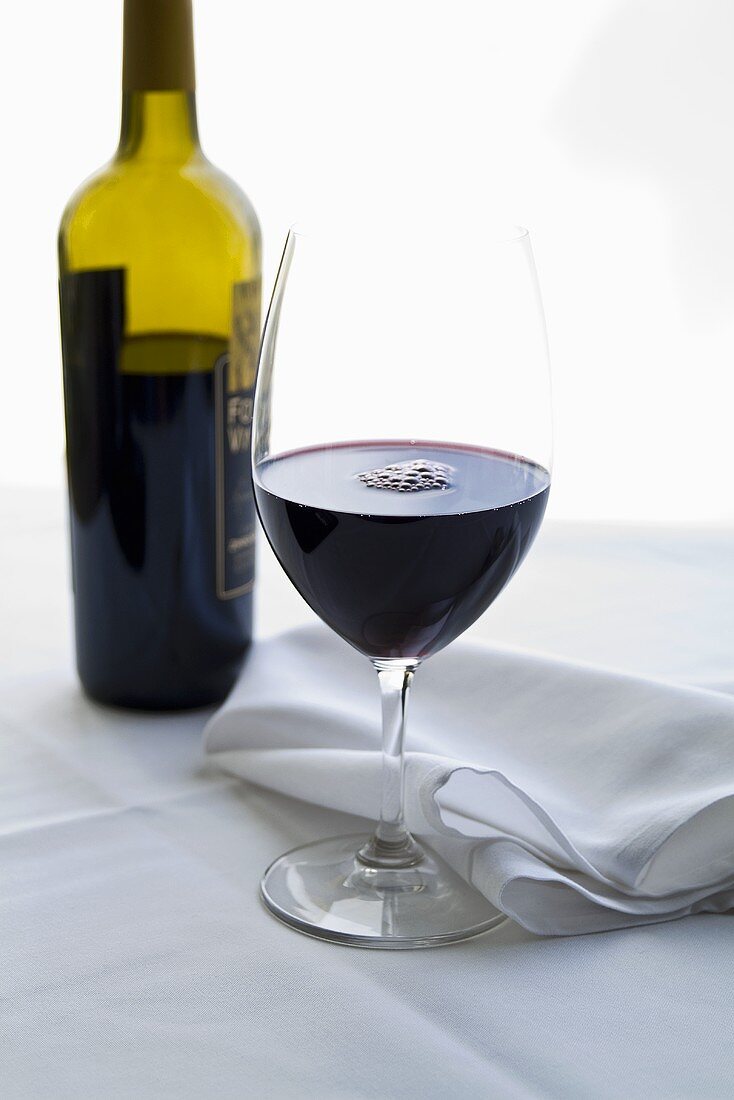 Glas und Flasche mit Rotwein