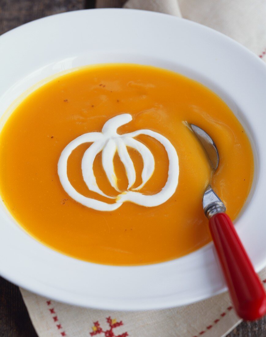 Bowl of Pumpkin Soup with Cream Garnish