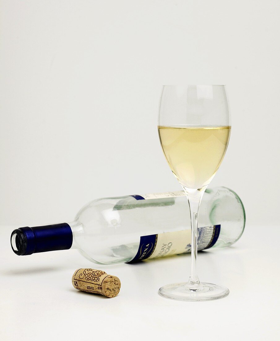 Glass of White Wine with Empty Bottle