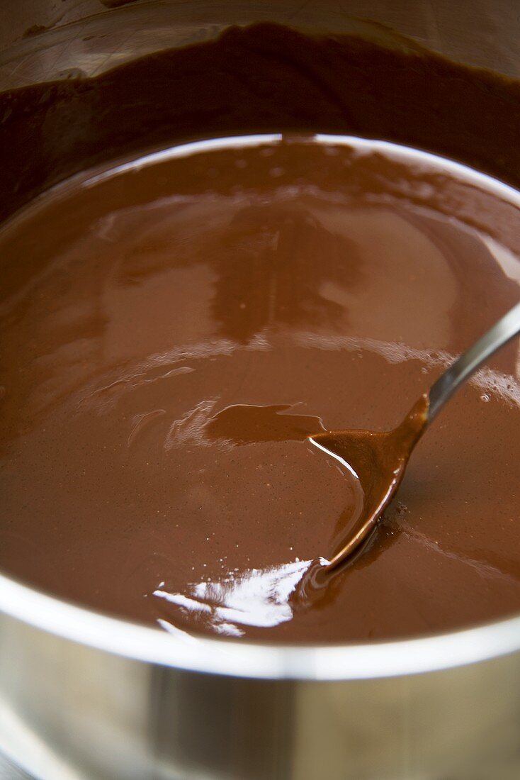 Geschmolzene Schokolade mit Löffel in einem Topf