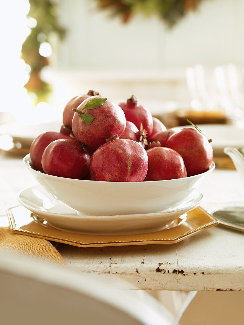 Frische Granatäpfel in Schale auf gedecktem Tisch