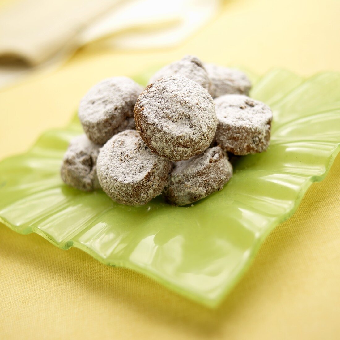 Chocolate Cookies with Powdered Sugar on Green Dish