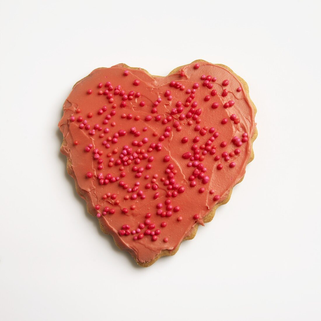Rotes Herzplätzchen mit Zuckerperlen zum Valentinstag