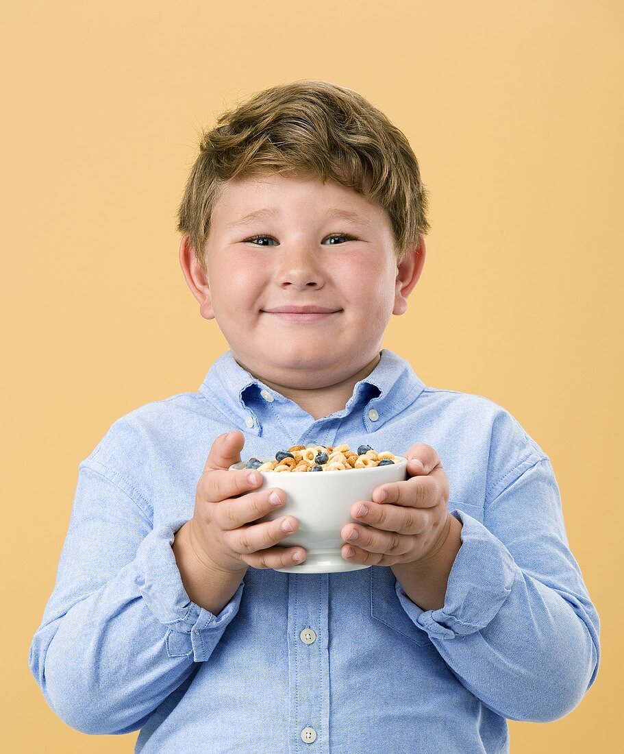 Little Boy Holding Bowl of Cereal with Fruit