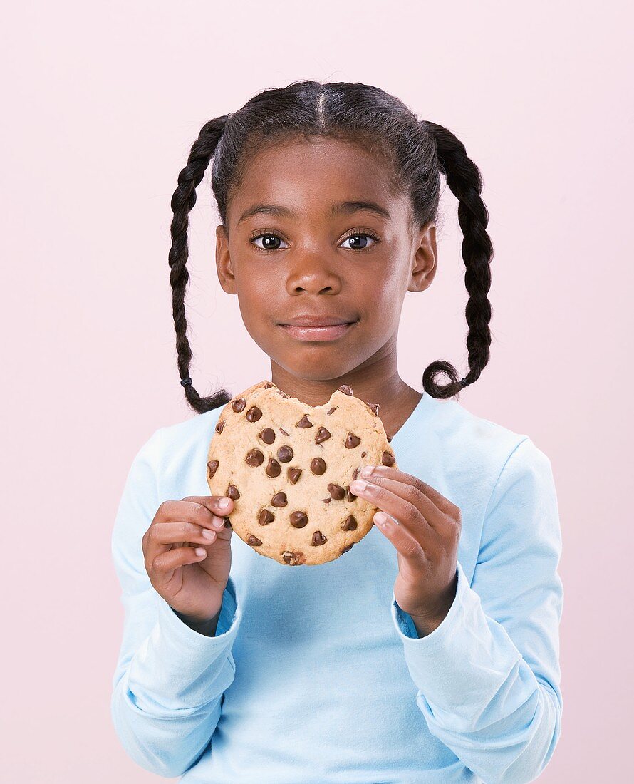 Mädchen hält angebissenen chocolate chip cookie in den Händen