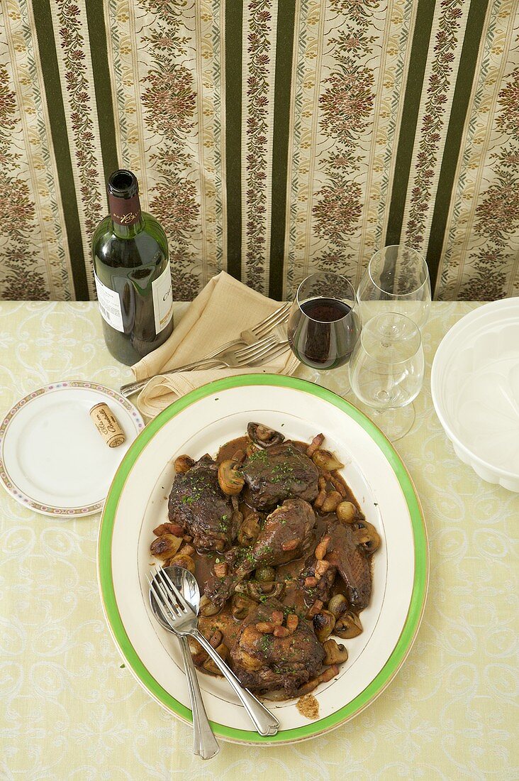 Coq au Vin on Table with Red Wine