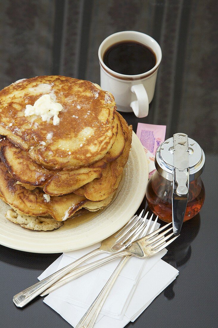 Gestapelte Pancakes mit Butter, Ahornsirup, Kaffee (USA)