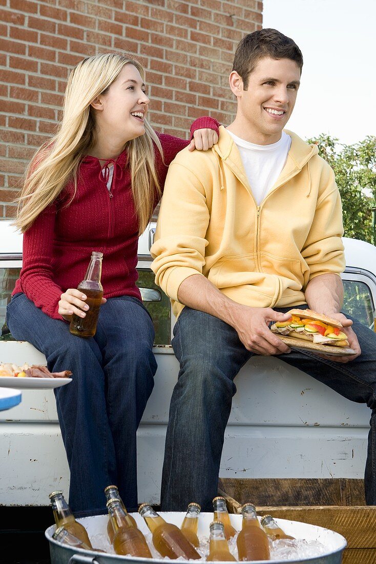 Man and Woman Tailgating with Beer and Sandwiches