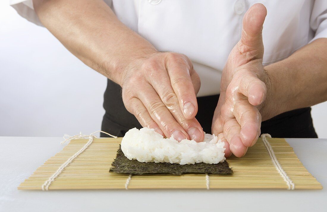 Maki-Sushi zubereiten (Reis auf Noriblatt verteilen)