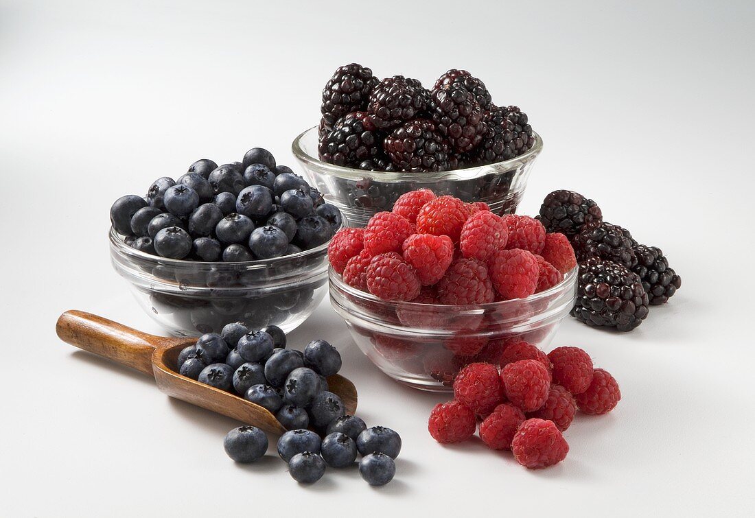 Fresh Blueberries, Raspberries and Blackberries in Glass Bowls and Scoop