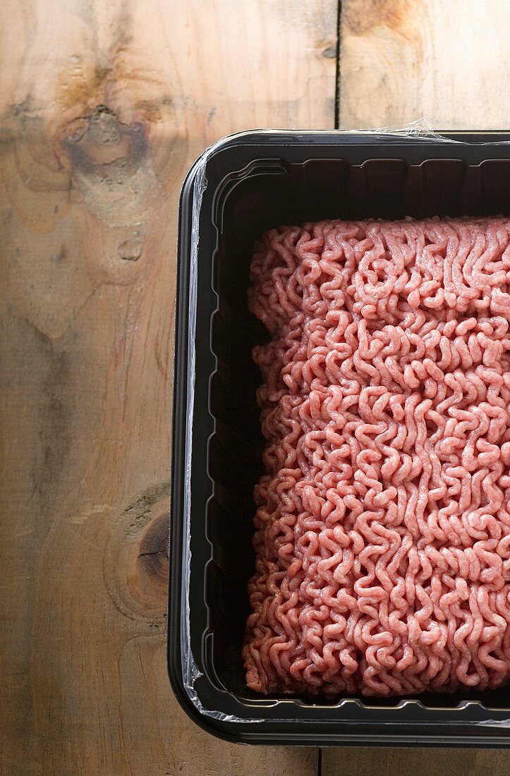 Ground Beef in Plastic Container on Wooden Table