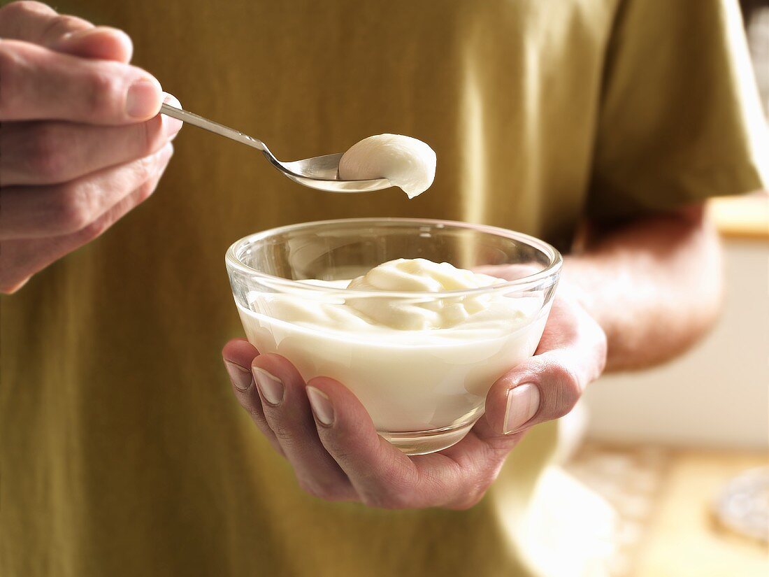A Man Taking a Spoonful of Vanilla Pudding