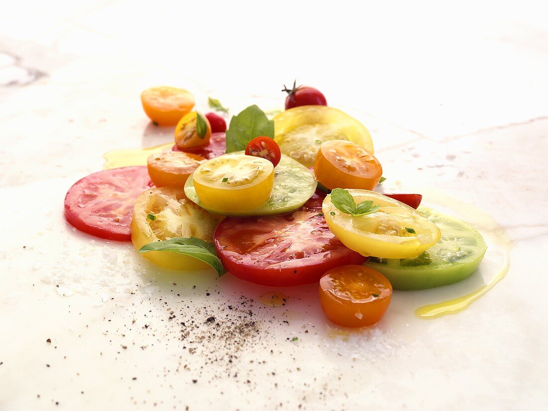 Tomatenscheiben mit Olivenöl, Pfeffer und Basilikum