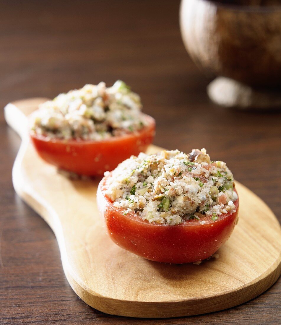 Two Stuffed Tomatoes on Cutting Board