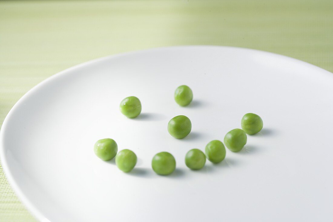 Peas Forming a Smiley Face on a White Plate