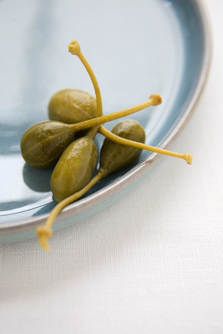 Four Caper Berries on a Plate