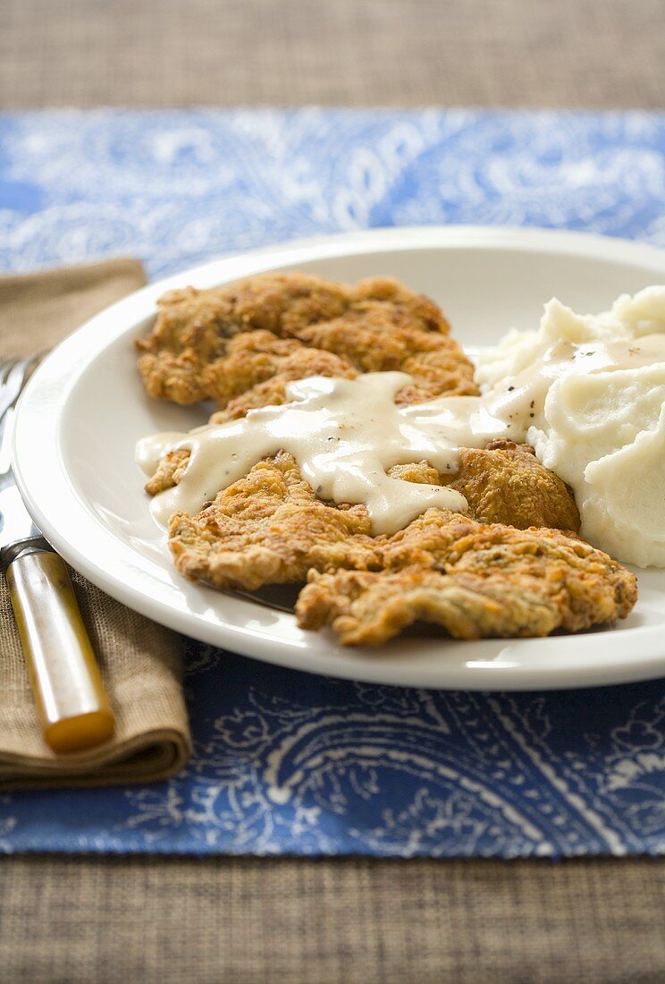 Paniertes Hühnerschnitzel mit Kartoffelpüree und Sauce