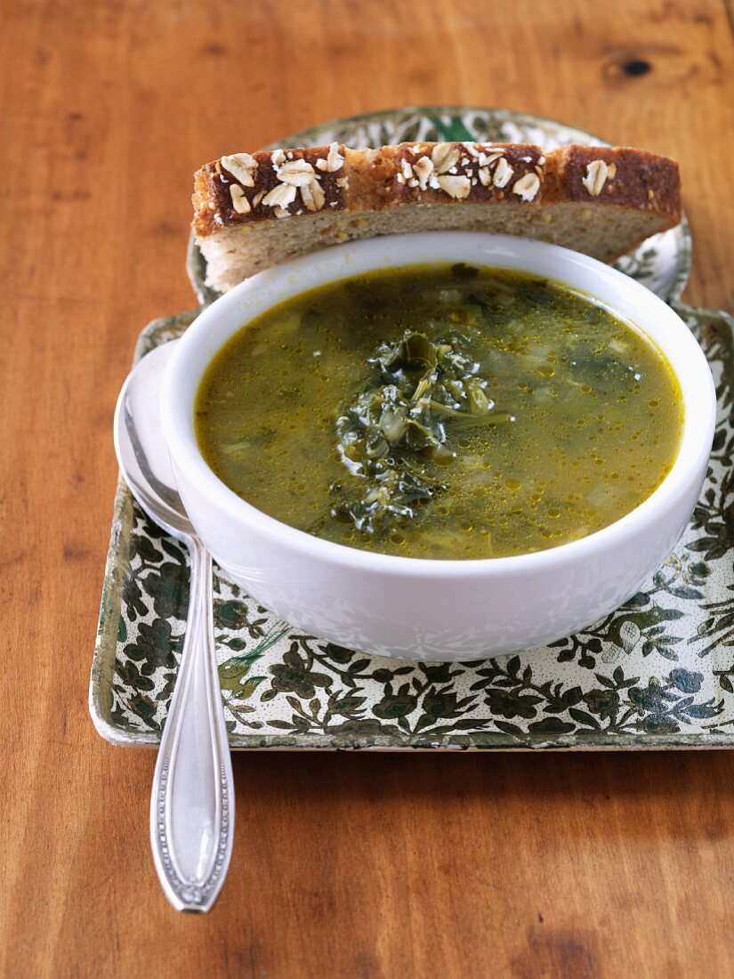 Bowl of Kale Soup with Slice of Whole Grain Bread