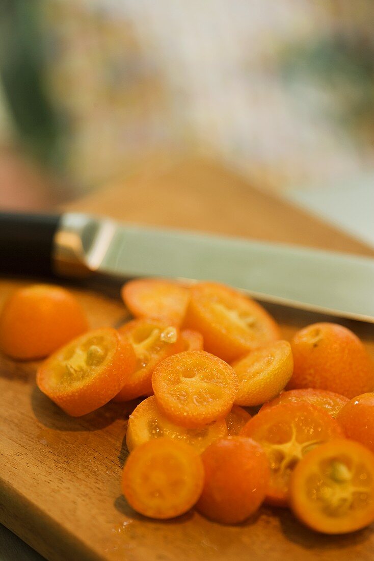 Geschnittene Kumquats auf einem Schneidebrett mit Messer