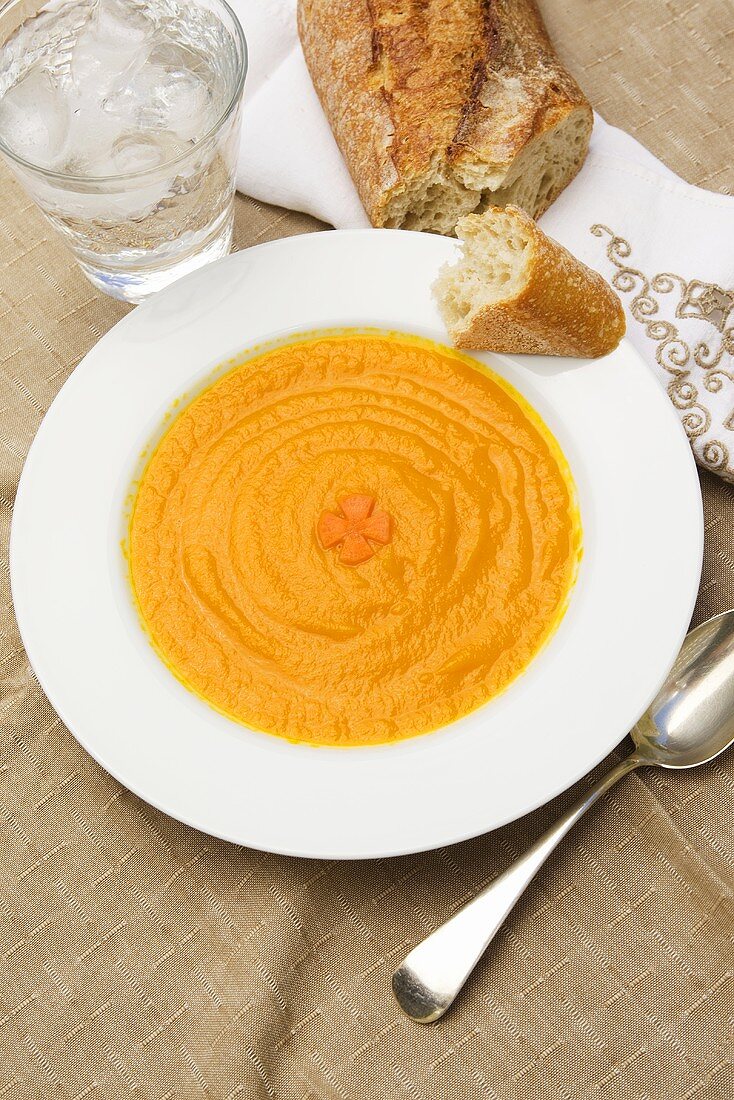 Bowl of Homemade Carrot Soup with Crusty Bread and Water