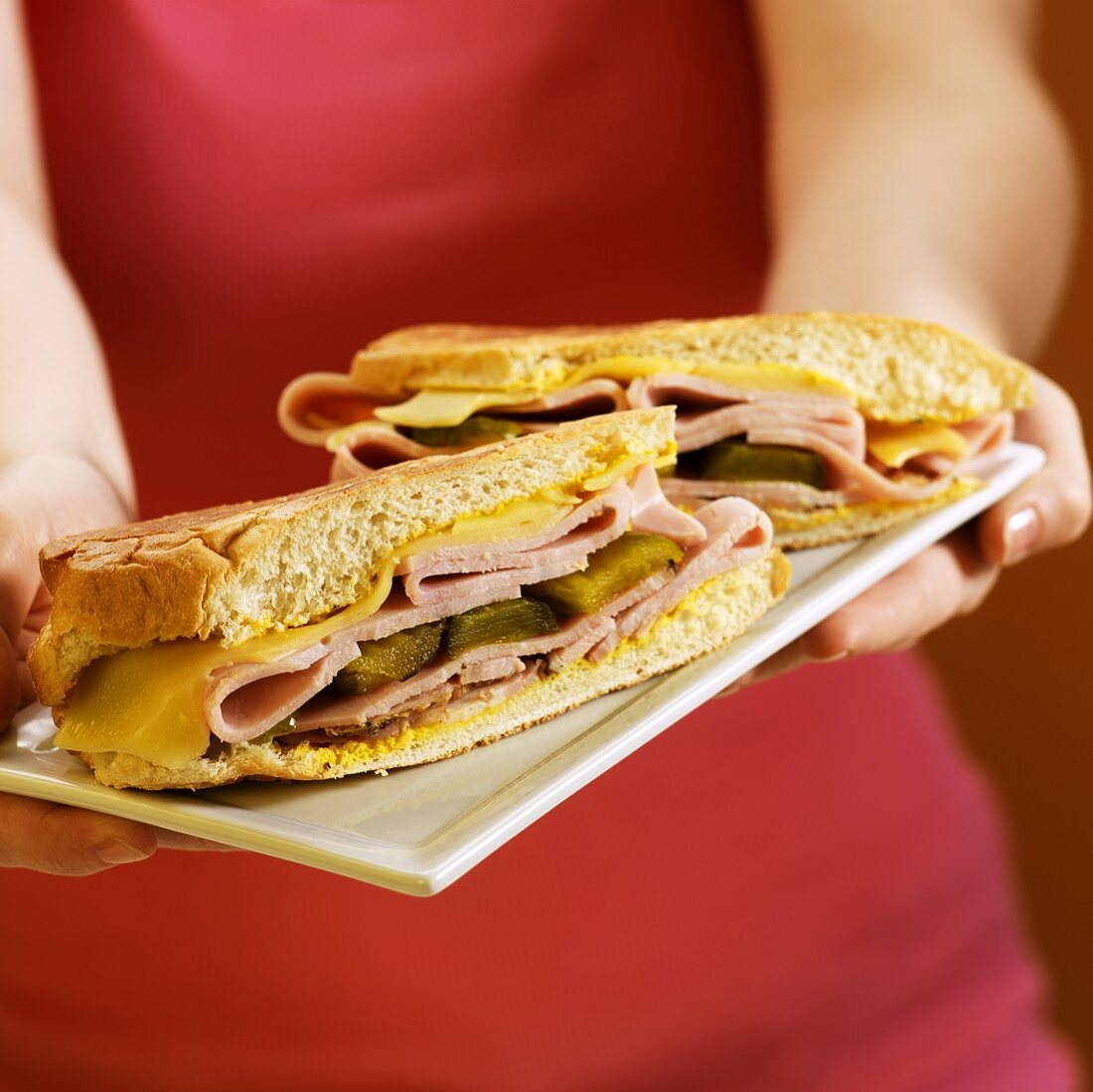 Frau hält Platte mit kubanischen Sandwiches