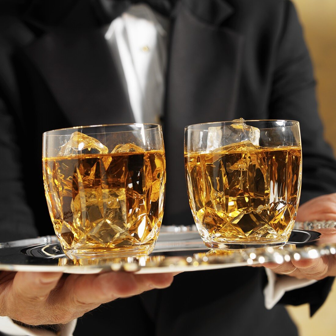 Waiter Serving Two Scotch on the Rocks on a Silver Platter