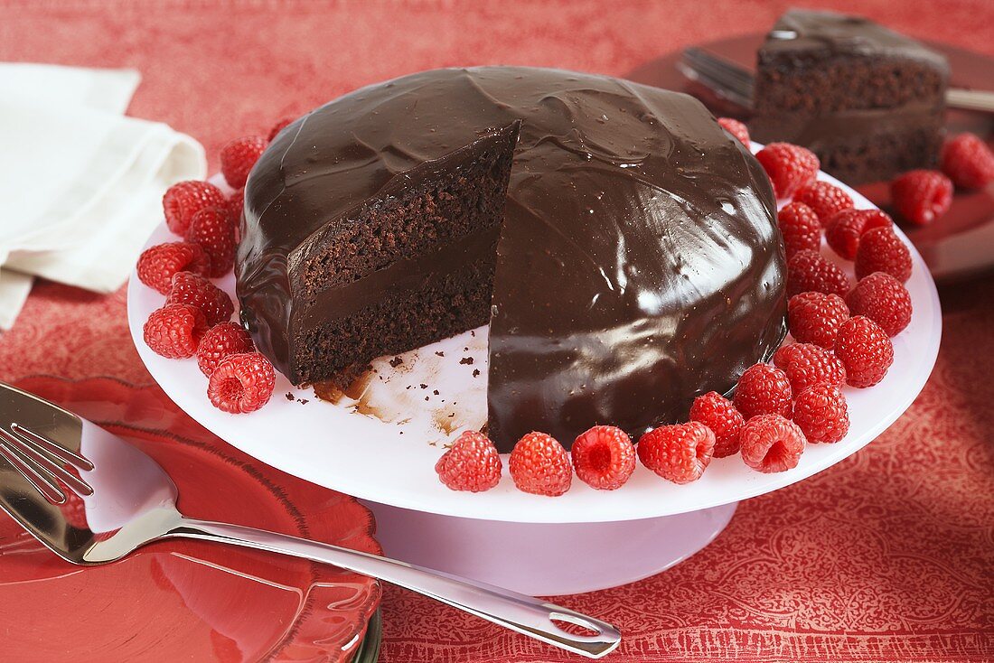 Double Layer Chocolate Frosted Cake with Raspberries; Slice Removed