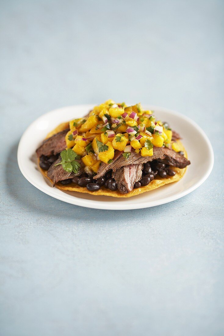 Tostada mit Rindersteak, Bohnen und Mangosalsa (Mexiko)