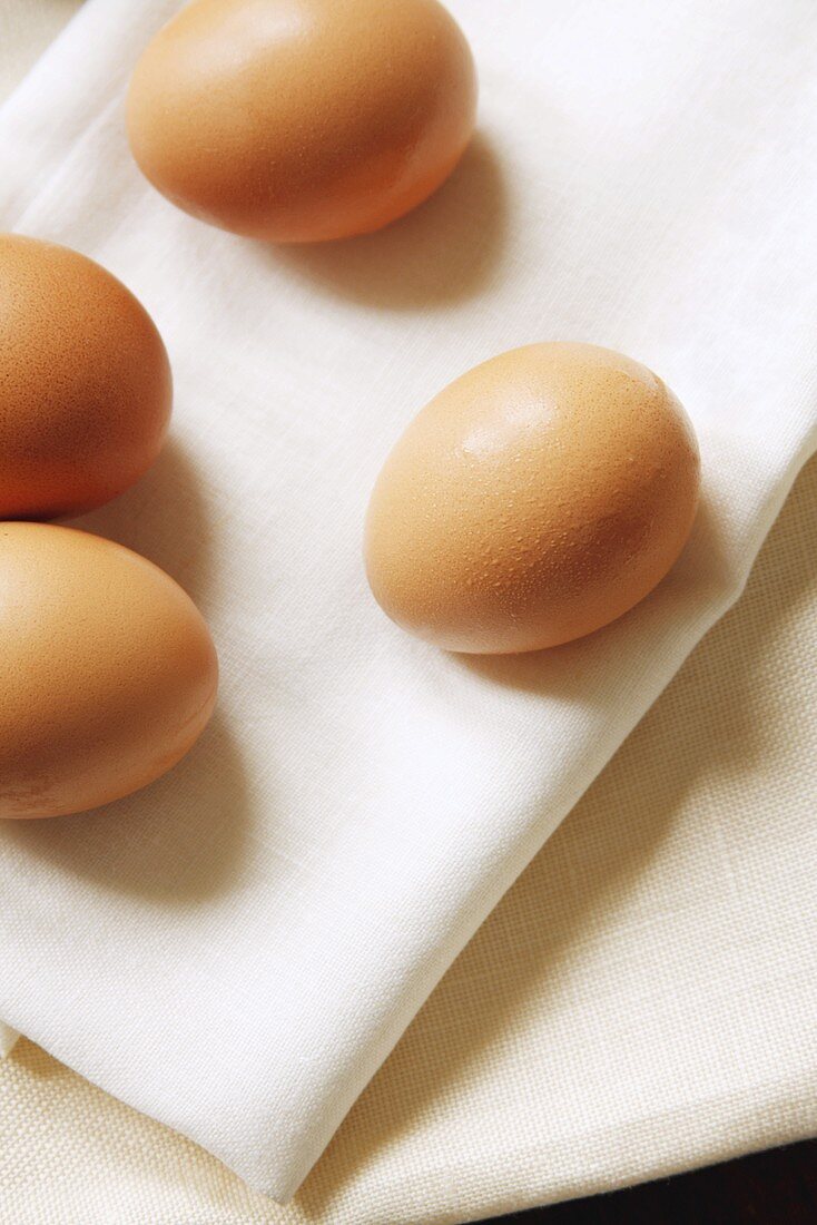 Vier braune Eier auf einer Leinenserviette