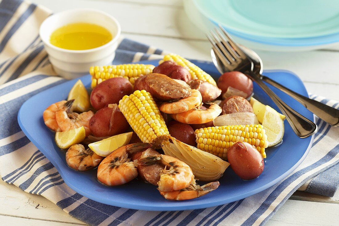 Shrimps, corn cobs and potatoes on a plate (New England, USA)