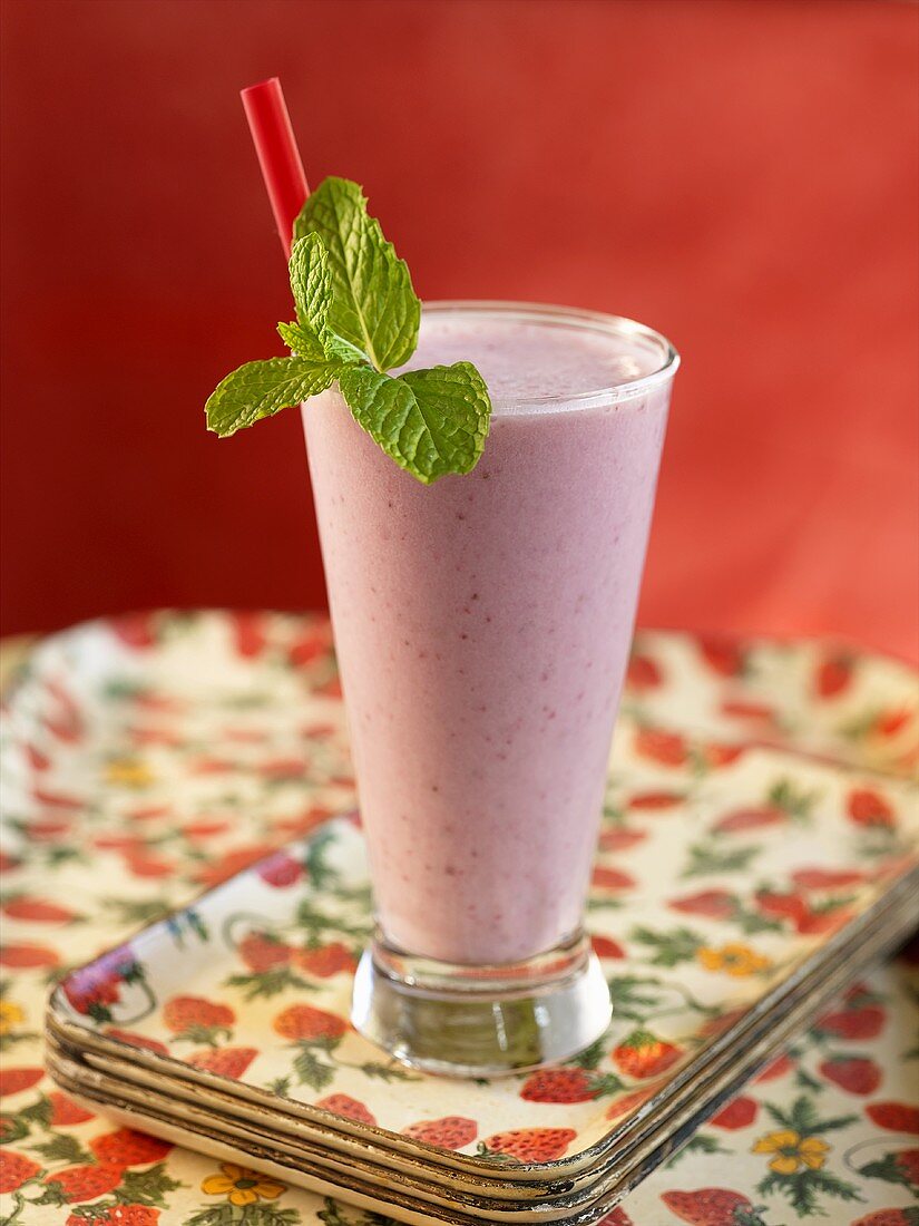 Strawberry Smoothie with Straw and Mint Garnish