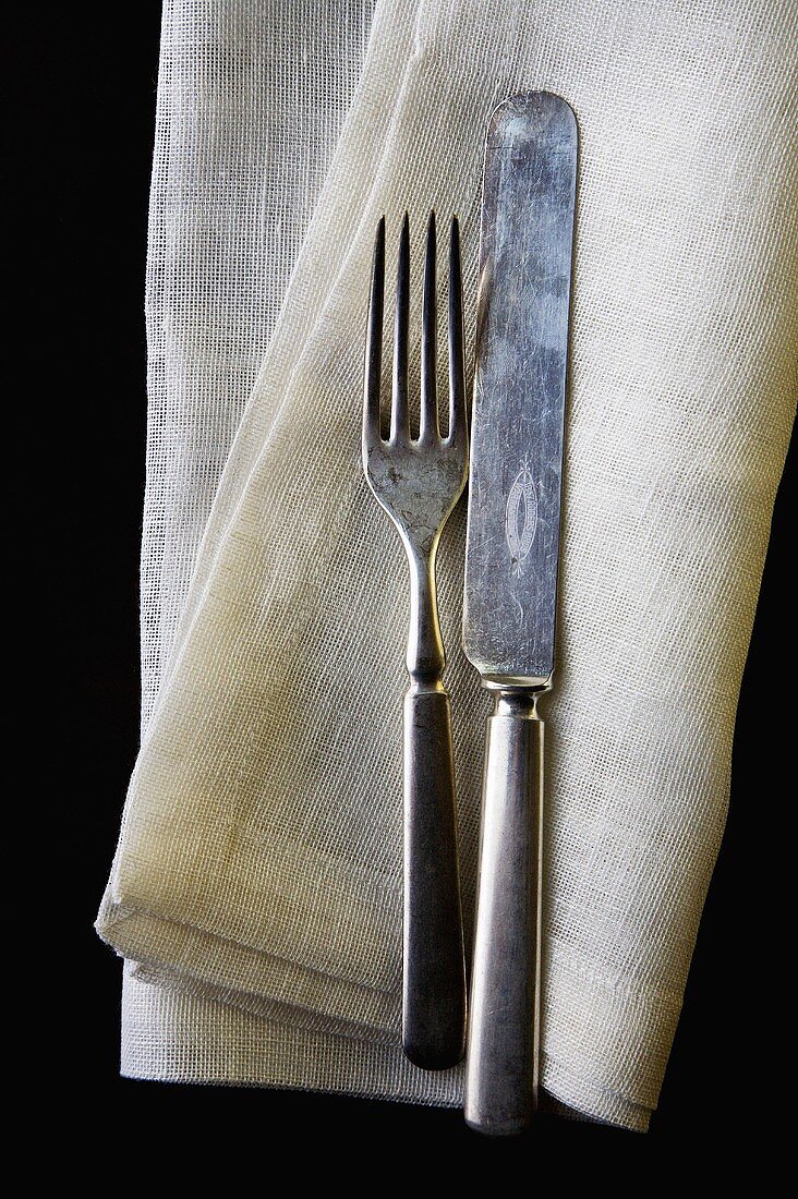 Old Fork and Knife on Linen Napkin