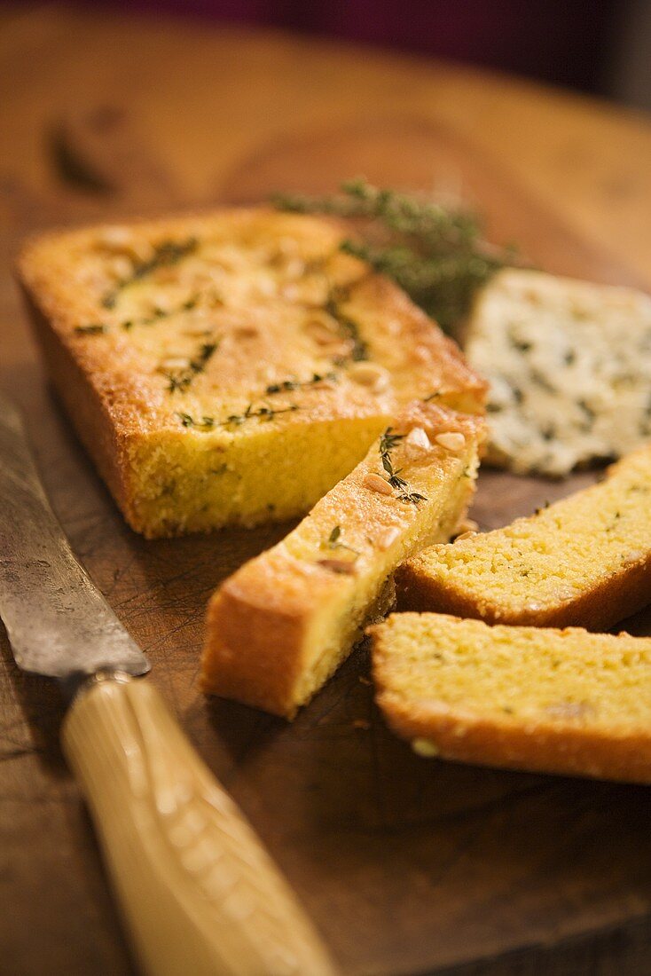 Partially Sliced Polenta Bread on Cutting Board; Knife