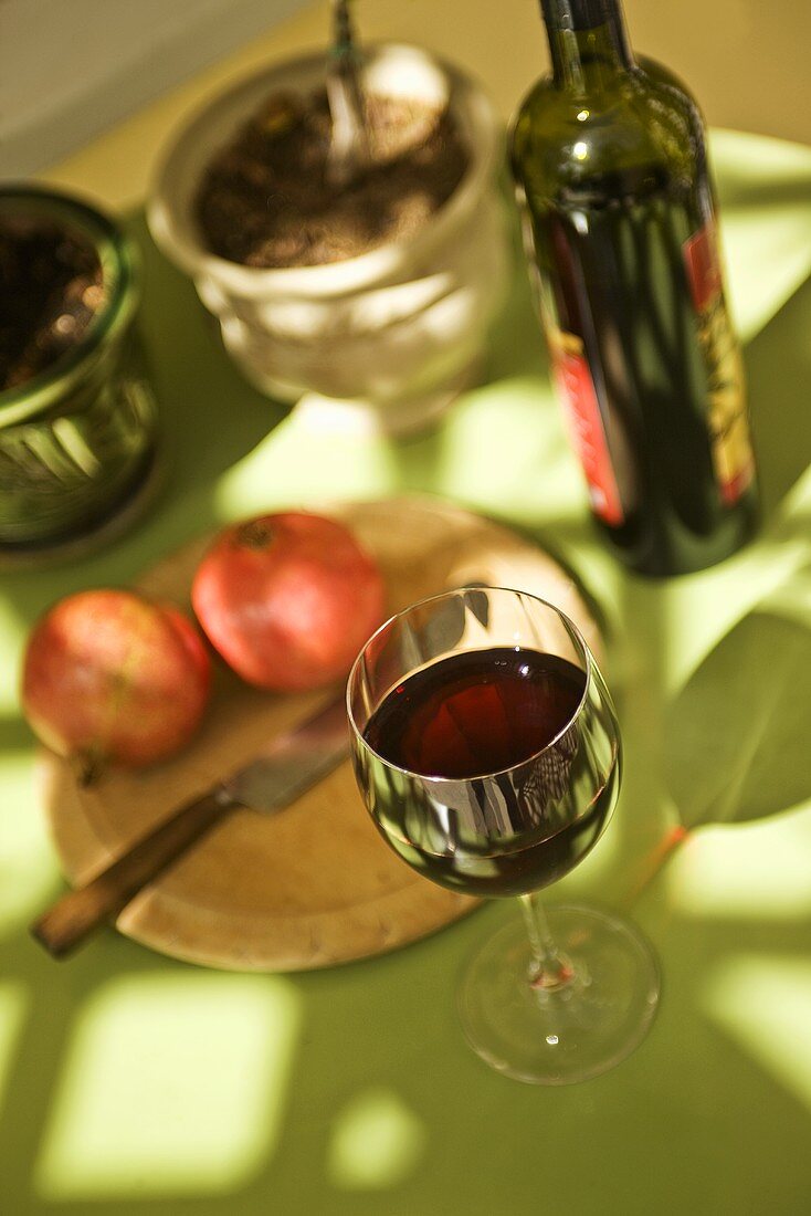 Glass of Pomegranate Wine; Bottle and Pomegranates