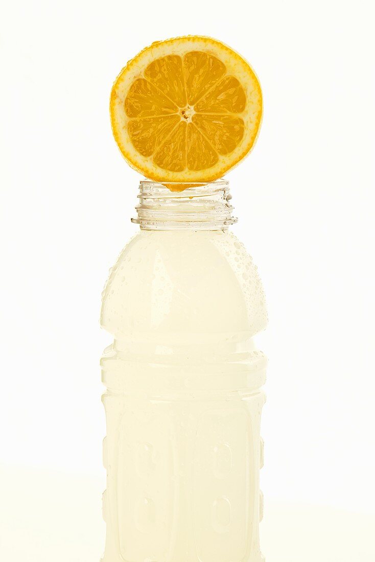 Halbe Zitrone auf Plastikflasche mit Fitnessdrink