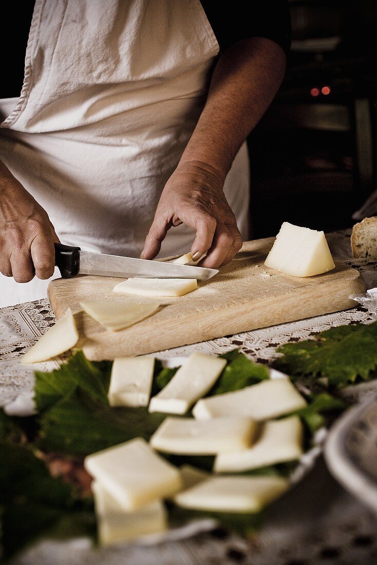 Man Slicing Cheese on Cutting Board