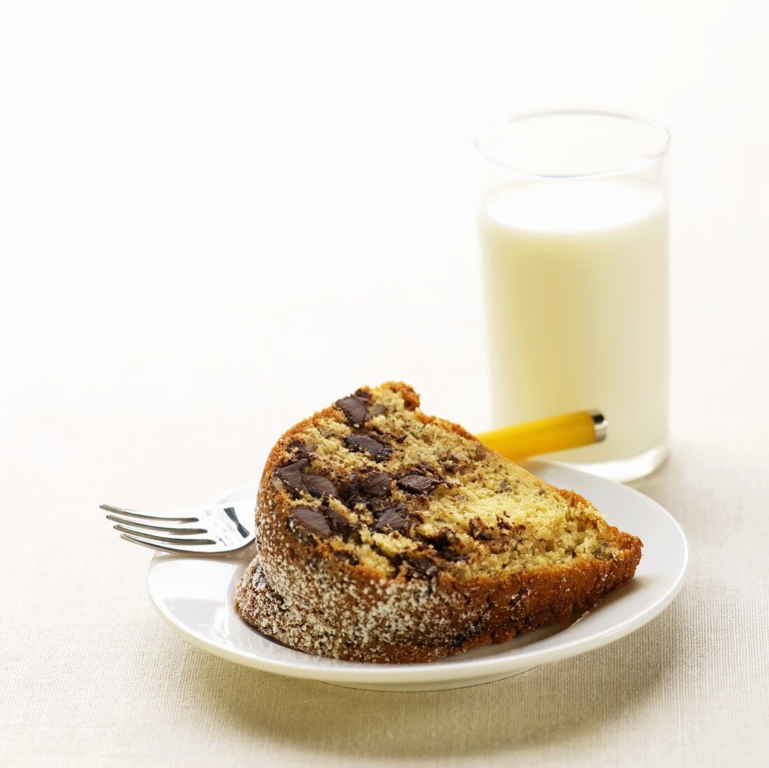 Stück Napfkuchen mit Chocolatechips und Glas Milch